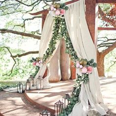 an outdoor wedding setup with white drapes and flowers