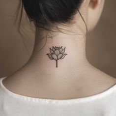 a woman's neck with a small lotus tattoo on her left side ribcage