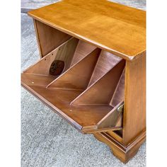 a wooden cabinet with three drawers on the bottom and one drawer open to show items inside