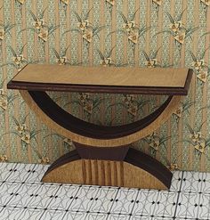 a wooden table sitting on top of a tiled floor next to a wallpapered wall