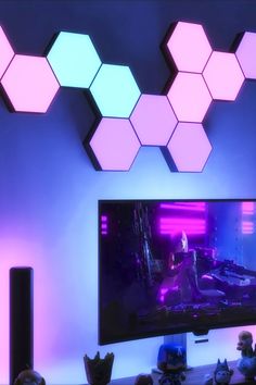 a flat screen tv sitting on top of a wooden table in front of a purple wall