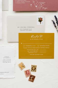 the wedding stationery is laid out on top of each other, including envelopes and stamps