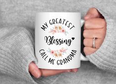 a woman holding a coffee mug with the words, my greatest blessing and grandma on it