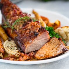 a white plate topped with meat and vegetables