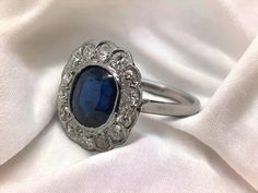 This beauty is a classic! Crafted in the Art Deco Era, 1920 - 1940, this stunning ring features a lovely blue sapphire surrounding by an array of old cut diamonds.  The blue sapphire is estimated to weigh 3.25 Carats & has a certificate from GIA, Gemological Institute of America. GIA concluded the stone to be natural & originating from Cambodia. The stone is also untreated, meaning the beauty is 100% natural!! Accenting the sapphire are 14 Old European Cut Diamonds, 2.5mm, IJ Color, SI1 Average Platinum Diamond Rings, Be Natural, European Cut Diamonds, Art Deco Era, Platinum Ring, Sapphire Diamond, Cambodia, Blue Sapphire, Wedding Rings Engagement