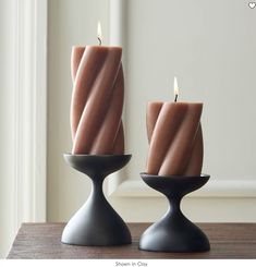 two candles sitting on top of a wooden table