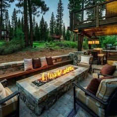 a fire pit in the middle of a patio with chairs and couches around it