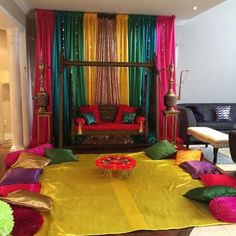 a living room decorated in bright colors and with lots of pillows on the floor,