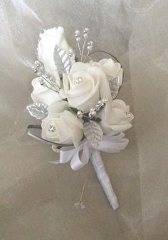 a bridal bouquet with white roses and crystal beads on it's headband