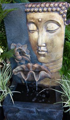 a buddha statue sitting next to some plants