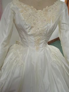 a white wedding dress on display in a room