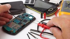 a man is working on an electronic device with many wires attached to the phone and other electronics