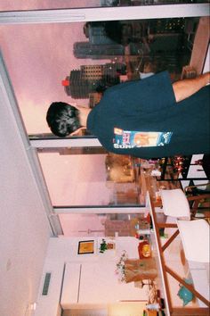 a man standing on top of a glass floor in front of a window next to a building