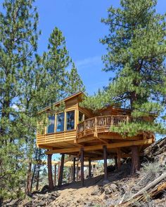 a tree house on top of a hill surrounded by trees