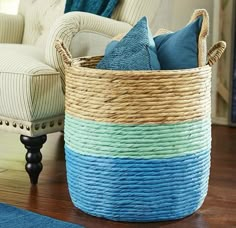 a large basket sitting on top of a wooden floor next to a chair and rug