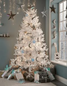 a white christmas tree with presents under it