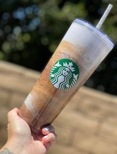 a person holding up a starbucks drink in their hand