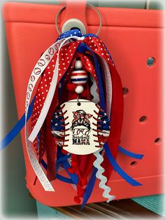 a red, white and blue christmas ornament hanging from a hook on a door