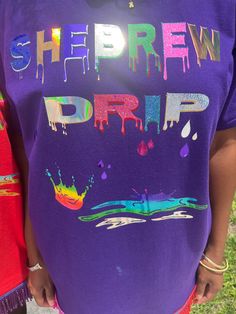 Show off your pride and heritage with the Drippy Shebrew T-shirt. This unique and eye-catching tee is perfect for any Israelite woman looking to flaunt their drip. Colorful Fringes: With six different colored fringes, this shirt is a beautiful representation of your culture. Light-Activated: The shirt is designed to catch the eye, especially in bright sunlight. Crew Neckline: The classic crew neckline makes this shirt a comfortable addition to any wardrobe. Fashionable Design: This t-shirt offers street style that's both fashionable and modest at the same time Feminine Touch: Shebrew Drip. Show off your Israelite culture with style in the custom-designed graphic pattern which ensures you stand out from the crowd wherever you go. With short sleeves designed specifically for women's tops, Th Drip Tshirt, Glitter Tshirt, Woman Looking, Graphic Patterns, Sleeve Designs, Gift For Women, Crew Neckline, Favorite Outfit, Gifts For Women