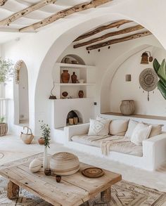 a living room filled with white furniture and lots of wood beams on the ceiling