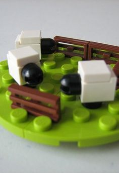 there is a toy train set on the green plate with black and white pieces in it