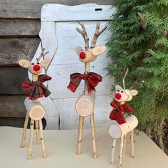 three wooden reindeers with red noses and plaid bows