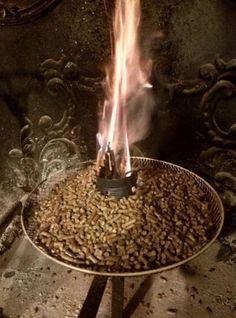 there is a fire burning in the middle of a bowl with coffee beans on it