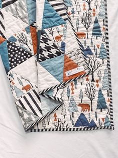 two quilts on top of each other with trees and animals in the woods printed on them