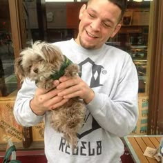 a man holding a small dog in his hands