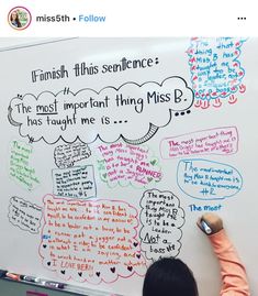 a person writing on a whiteboard with different types of speech bubbles attached to it