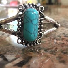 a turquoise stone ring sitting on top of a counter