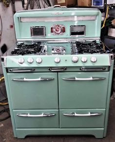 an old fashioned green stove in a garage