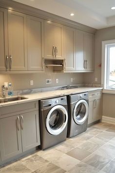 a kitchen with two washers and a sink in the middle, next to a window