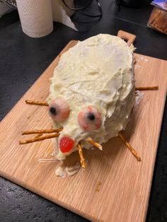 a cake shaped like a mouse on top of a wooden cutting board