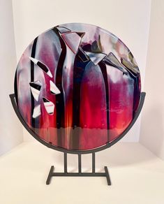 a glass plate sitting on top of a metal stand in front of a white wall