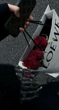 someone is holding a bouquet of roses in front of the camera with their cell phone