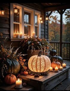 some pumpkins and candles on a porch