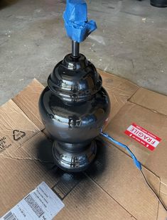 a large metal object sitting on top of a cardboard box