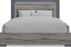 a bed with white pillows and grey wood headboard