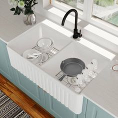 a white kitchen sink sitting next to a window