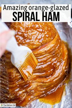 A spiral-cut ham on foil being glazed with a silicone pastry brush full of orange sauce held by a person's hand. The image includes text saying, Amazing orange-glazed SPIRAL HAM. Sauce For Spiral Ham, Glaze For Spiral Sliced Ham, Dinner Ham Recipes, Spiral Ham Glaze Recipe, Cooking A Spiral Ham, Ham Glaze Recipe Easy, Orange Ham Glaze, Cooking Spiral Ham, Orange Glazed Ham