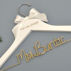 a wedding hanger with the word mr and mrs written on it next to some flowers