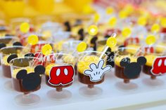 mickey mouse cupcakes are lined up on a table with candy and candies