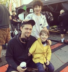 a man sitting next to a little boy on top of a table