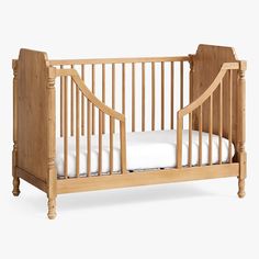 a small wooden crib with white sheets on the bottom and sides, against a white background