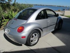 a silver car parked on the side of a road next to a body of water