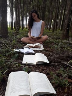 a woman sitting on the ground reading a book