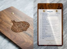 a wooden menu board sitting on top of a marble counter next to a clipboard