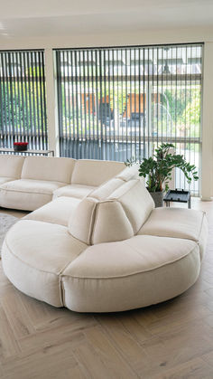 a living room filled with white furniture and large windows