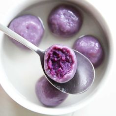 a bowl filled with blueberry souffle on top of a white table next to a spoon